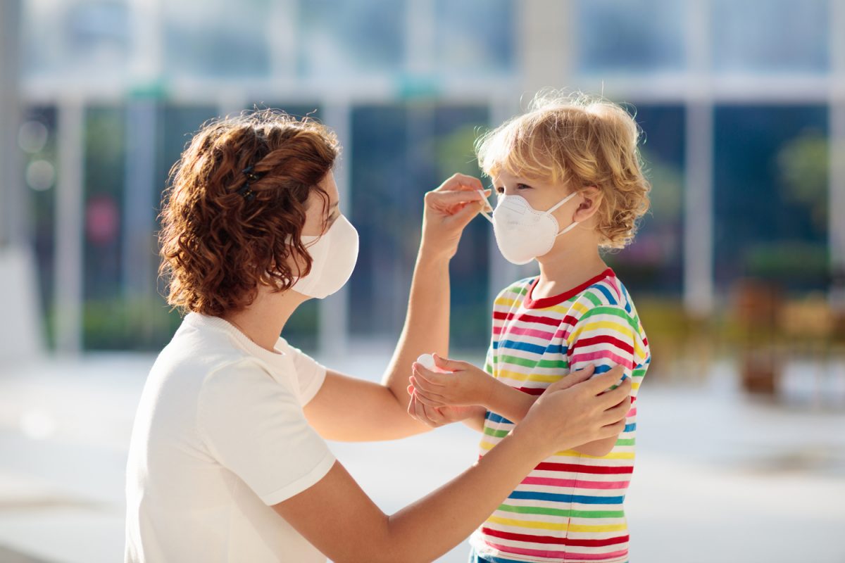 UAE COVID update: Mother adjusting face mask on child outside