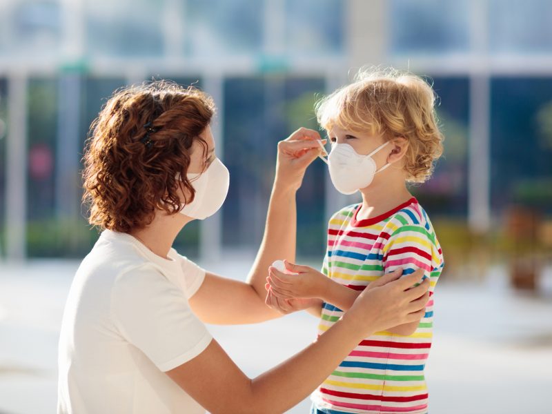 UAE COVID update: Mother adjusting face mask on child outside