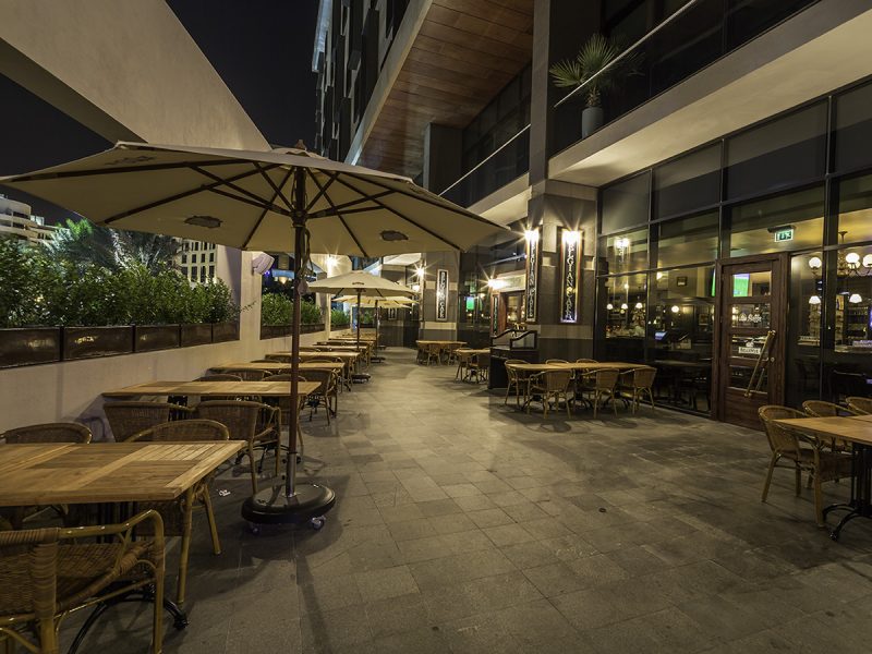 Belgian Café birthday party: umbrellas and tables outside at night