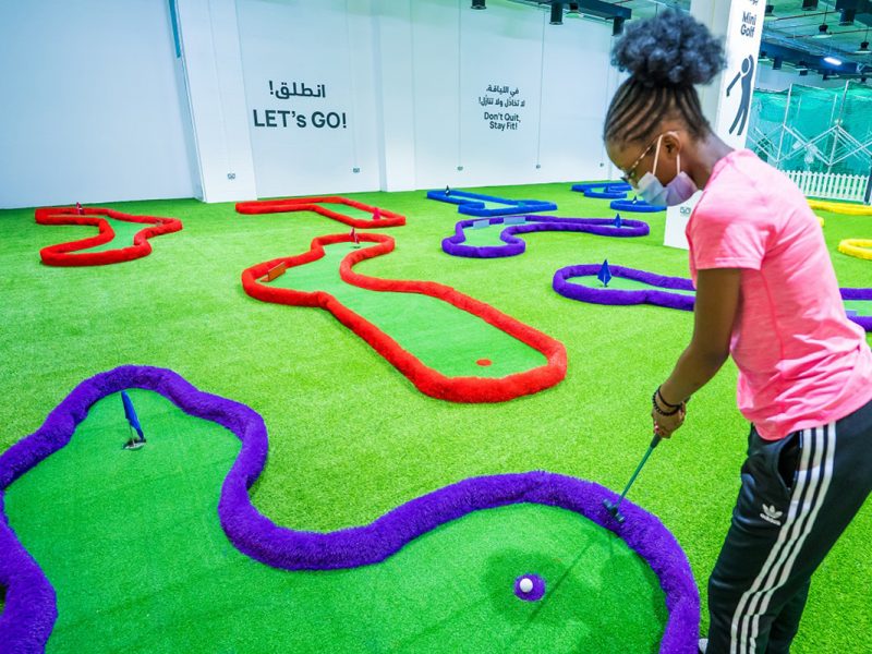 Fit4Fun: Mini Golf, girl putting at green indoors