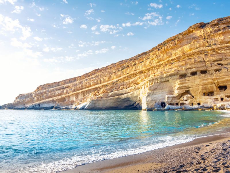 Crete Island, Greece: Matala beach with caves on the rocks that were used as a roman cemetery and at the decade of 70's were living hippies from all over the world, Crete, Greece