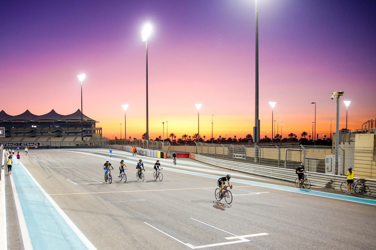 cyclists enjoying free fitness classes at yas marina circuit at sunset