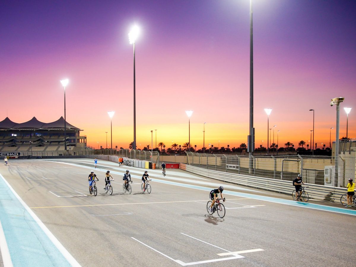 cyclists enjoying free fitness classes at yas marina circuit at sunset