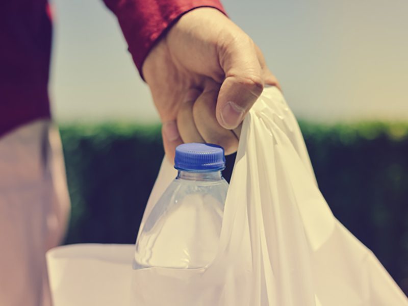 Abu Dhabi to ban single-use plastic bags: man carrying plastic bag with water bottle